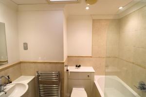 a bathroom with a toilet and a sink and a tub at Addlestone - Large Stunning 2 bed room Apartment in Addlestone