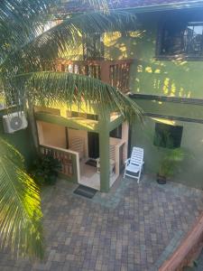 a house with a white chair and a palm tree at Hidden oasis in Mandeville