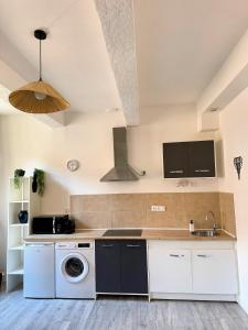 a kitchen with a washing machine and a sink at Narbonne centre Dame Nature in Narbonne