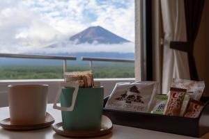 two cups on a table with a view of a mountain at Hotel Regina Kawaguchiko in Fujikawaguchiko