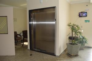 a metal elevator in a hallway with a potted plant at Aero Plaza Hotel in Sao Paulo