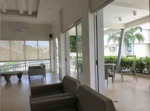 a living room with a couch and chairs and windows at Makai Home at Marian Spatial Dumaguete in Dumaguete