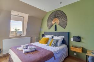 ein Schlafzimmer mit einem großen Bett mit einem Ventilator an der Wand in der Unterkunft Villa des Berges - 7 Chambres et 6 Salles de bain in Bourbourg