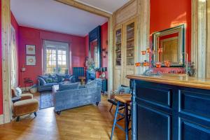 ein Wohnzimmer mit roten Wänden und einer Bar in der Unterkunft Villa des Berges - 7 Chambres et 6 Salles de bain in Bourbourg