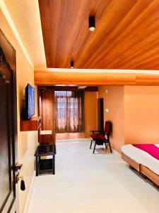 a bedroom with a bed and a television in a room at City Palace Hotel in Ooty