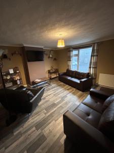 a living room with two couches and a table at Viewlands house in Auchterarder