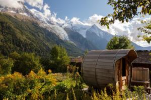 a wooden cabin with mountains in the background at Auberge du Bois Prin in Chamonix