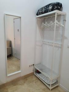 - Armario blanco con espejo en la habitación en Habitaciones Chueca, en Madrid