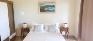 a bedroom with a bed with pillows and a picture on the wall at Hotel Barra da Ferrugem Eco Village in Garopaba +31 photos