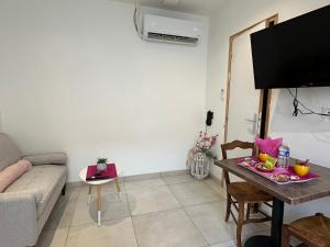 een woonkamer met een bank en een tafel bij Chez Camille & Emma - Climatisé in Rochefort