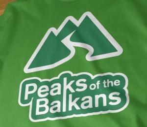 a green bag with the peaks of the bakans on it at Dedushi Guesthouse &Wood cabins-Camping place in Gusinje