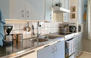 a kitchen with white cabinets and a sink at Cozy Home In Strömsnäsbruk With Wifi in Strömsnäsbruk