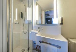 a white bathroom with a sink and a shower at B&B HOTEL La Rochelle Angoulins in Angoulins-sur-Mer +20 photos
