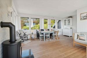 a living room with a wood stove and a table at Idyllic Holiday Home Near Cliffs And Beach in Gudhjem +10 photos