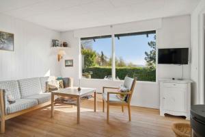 a living room with a couch and a table and a window at Idyllic Holiday Home Near Cliffs And Beach in Gudhjem