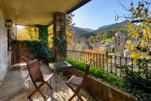 two chairs and a table on a balcony with a view at Hotel Rural El Mirador de los Pirineos in Santa Cruz de la Serós +39 photos