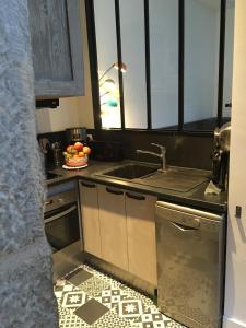 a kitchen with a sink and a bowl of fruit at L'Annexe Apparthôtel du 11 D, 3 étoiles in Besançon +15 photos
