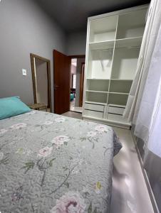 ein Schlafzimmer mit einem Bett und einer Kommode in der Unterkunft Casa para família em Bombinhas in Bombinhas
