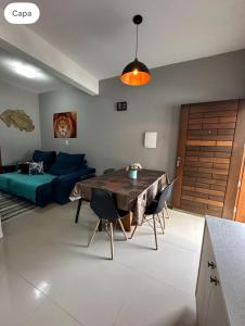 ein Wohnzimmer mit Tisch und Couch in der Unterkunft Casa para família em Bombinhas in Bombinhas