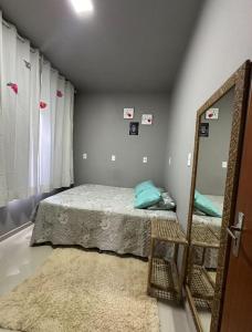 Schlafzimmer mit einem Bett und einem Spiegel in der Unterkunft Casa para família em Bombinhas in Bombinhas