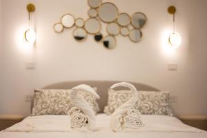 a bed with towel swans on it with two lights at Enjoyhousebracciano Suite 3 in Bracciano