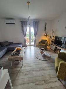 una sala de estar con un sofá y una mesa en Apartments Joy, en Cavtat