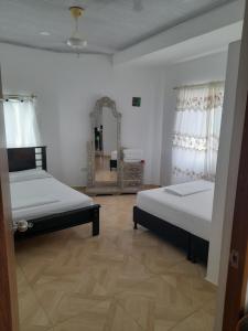 a bedroom with two beds and a mirror at Apt vacacional 301 in Doradal +8 photos