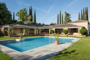 a house with a swimming pool in front of a yard at Cigarral del Carmen in Toledo