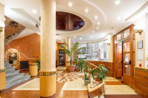 a lobby with a column and potted plants at Wellness Hotel Jean De Carro in Karlovy Vary