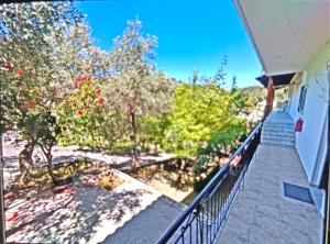 a balcony of a house with trees and stairs at Pool me up 22 apartment in Megali Ammos