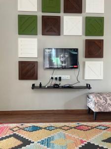 un soggiorno con una TV a schermo piatto su una parete di La Calma Private Pool a Jitra