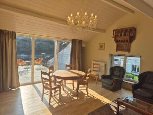 a living room with a table and chairs and a chandelier at Panama RIO in Waulsort