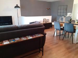 a living room with a couch and a table and chairs at Les paliers du Saulou in Fumel