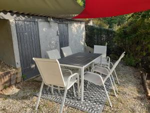 a table and chairs sitting under a red umbrella at Les paliers du Saulou in Fumel