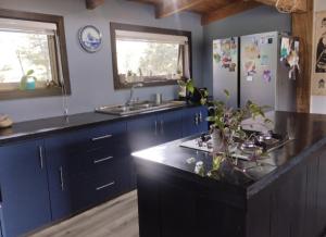 a kitchen with blue cabinets and a black counter top at Hermosa casa en Palguin Bajo in Minetué