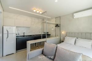 a small bedroom with a bed and a kitchen at Lindo Estúdio Funcional em Goiânia SLV0011 in Goiânia