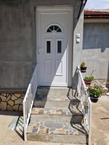 a white door on a house with stairs at Apartman VRANJANKA in Vranje