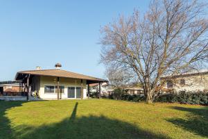 a house with a large yard with a tree at Villa Ceratti in Cassano Magnago
