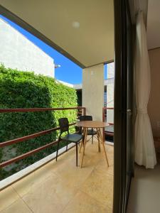 a patio with a table and chairs on a balcony at Loft Vila Murici in Flecheiras