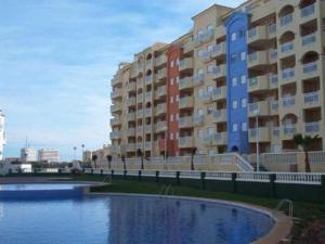 un gran edificio de apartamentos junto a una masa de agua en Apartamentos Turísticos Puerto Tomás Maestre, en La Manga del Mar Menor