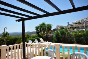 a balcony with white chairs and a swimming pool at Villa Romantica 17 in Milas