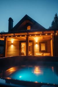 a house with a hot tub in front of it at Szürke Szarvas in Szuha