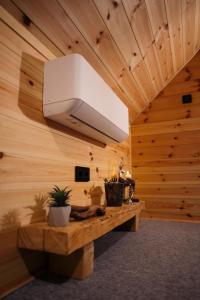 a room with a wooden ceiling with a light and a bench at Szürke Szarvas in Szuha
