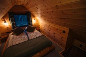 a bedroom with a bed in a log cabin at Szürke Szarvas in Szuha