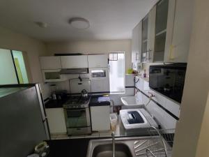 a small kitchen with white cabinets and a sink at Departamento Centenario in Lima +6 photos