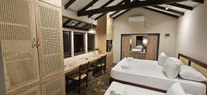 a room with two beds and a desk and a sink at Cinta Hiriketiya in Dickwella