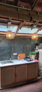 a kitchen counter with a sink and two lights at Cinta Hiriketiya in Dickwella