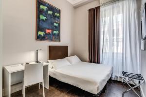 Un dormitorio con una cama y un escritorio y una ventana. en Guest House Cavour 278, en Roma