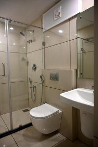 a bathroom with a shower and a toilet and a sink at Harley Residency in Kannur