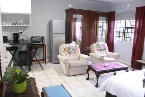 a living room with two chairs and a table at Urban Gardens in Gqeberha